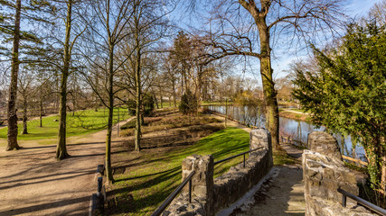 Fototapeta na wymiar View of the Proosdij Park from a bridge with its trees, river, green grass and trails, wonderful sunny winter day in Meerssen south Limburg in the Netherlands Holland
