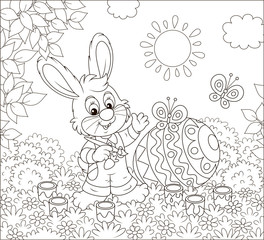 Little bunny coloring a big Easter egg on grass among flowers on a sunny spring day, black and white vector illustration in a cartoon style