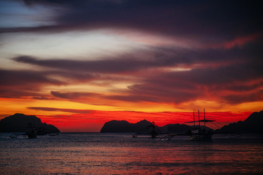 Traditional philippine boats in Corong-Corong beach in El Nido at sunset lights. Palawan island, Philippines