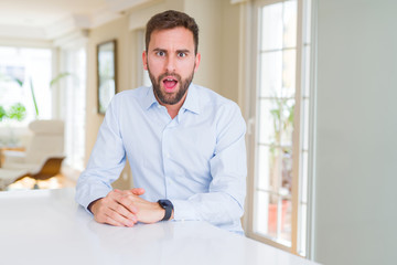 Fototapeta premium Handsome business man afraid and shocked with surprise expression, fear and excited face.