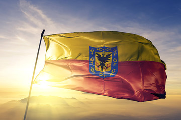 Bogota Capital District of Colombia flag waving on the top sunrise mist fog
