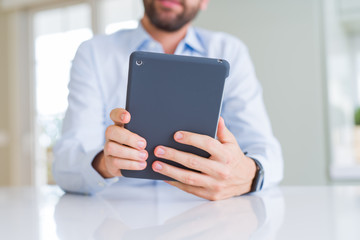 Close up of man hands using tablet and smiling