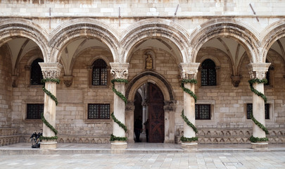 Fototapeta na wymiar Columns and exterior of the Duke's Palace (Knezev dvor) decorated with Advent wreaths in Dubrovnik, Croatia 