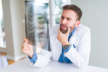 Fototapeta premium Doctor man looking at x-ray radiography doing body examination