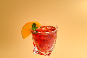 Red fresh drink with ice, grapefruit and mint on an beige background. Space for text or design.