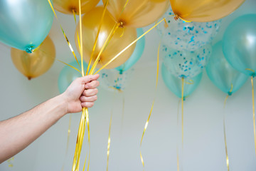 balloons blue and gold color in man's hand