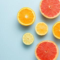 Colorful sliced fruits background. Grapefruit, lime, lemon and orange on blue background