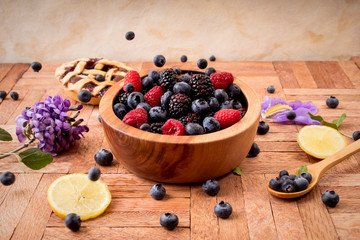 Mix of blueberries, blackberries and raspberries in a wooden bowl - healthy breakfast