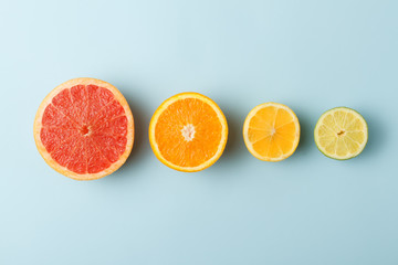 Colorful fruits in row on blue background. Grapefruit, orange, lemon and lime