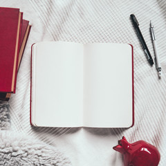 Flat lay of cozy workplace: opened sketchbook, pen and pencil