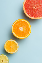 Sliced grapefruit, orange, lemon and lime fruits on blue background
