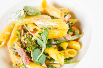 Pasta - penne with bacon and broccoli, decorated with herbs 