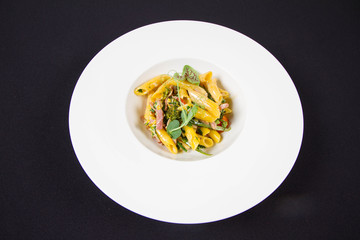 Pasta - penne with bacon and broccoli, decorated with herbs 