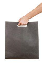 Hand with blank black paperboard bag isolated on white background