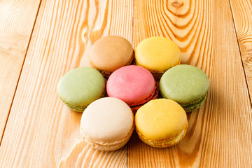 Closeup of colorful macaroons on natural wooden background 