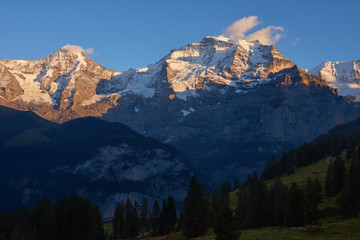 View of Jungfrau and Monch mountains at sunset in Lauterbrunnen in Switzerland.