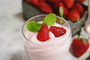 Homemade Strawberry Mousse topped with berries and mint leaf garnish, selective focus