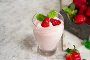 Homemade Strawberry Mousse topped with berries and mint leaf garnish, selective focus