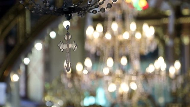 Great chandelier lamp with a little cross in the church.