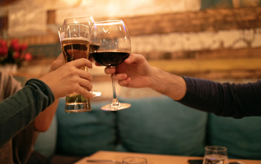 Friends in a restaurant toasting beer and wine. Three Friends in restaurant celebrating. Evening go out