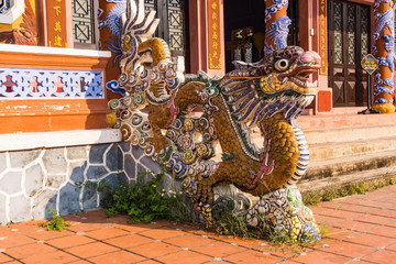 elaborate artistic ancient dragon at entrance to temple made with inlaid mosaic ceramic pieces
