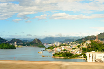 Naklejka premium Aerial view of the beautiful city of Vitoria, Espirito Santo, Brazil and its wide bay. The city developed with its high buildings growing on the hills and into the local greenery