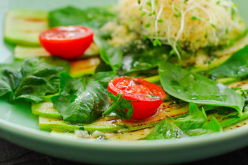 zucchini grilled with tomatoes and cream cheese, sauce and micro-greens (warm salad appetizer). food background. copy space