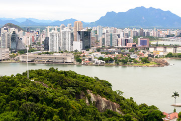 Fototapeta premium Aerial view of the beautiful city of Vitoria, Espirito Santo, Brazil and its wide bay. The city developed with its high buildings growing on the hills and into the local greenery