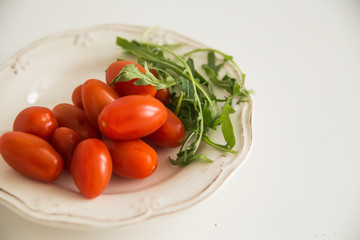 tomatoes and greens on the white table