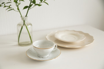white cup and saucer on white table