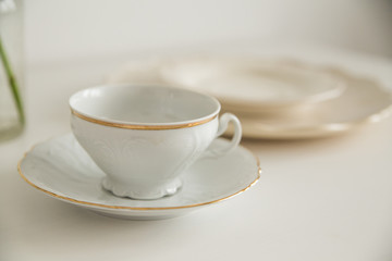 white cup and saucer on white table