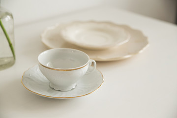 white cup and saucer on white table