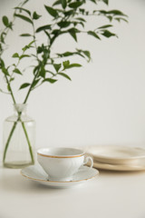 white cup and saucer on white table