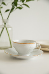 white cup and saucer on white table