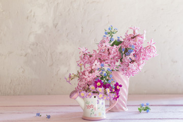 spring flowers in vases on wooden table