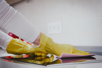 Housewife cleaning an induction plate, closeup shot