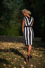 beautiful blonde woman in the autumn forest at sunset