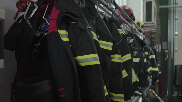 Firefighter uniforms and equipment hanging in row in fire station