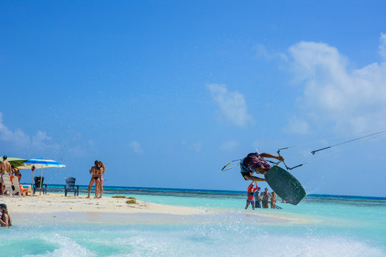 Young and talented rider JUMPING and flying ON THE BEACH . kitesurf sport in los Roques Venezuela