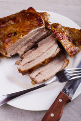 Thigh turkey baked in the oven with spices on a white plate on the tabletop. Healthy food. Thanksgiving dinner.