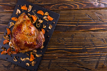 Thigh turkey baked in the oven with spices on black stone board. Healthy food. Thanksgiving dinner.