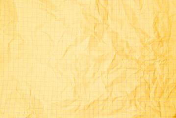 One crumpled yellow blank paper sheet of a notebook  in grid (background)
