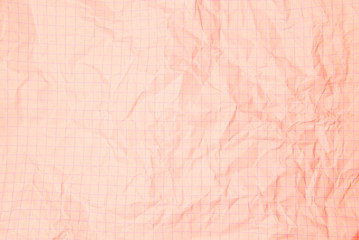 One crumpled pink blank paper sheet of a notebook  in grid (background)