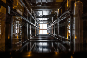 The passenger lift shaft seen from the glass cabin, a glazed roof at the top. - obrazy, fototapety, plakaty