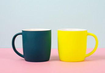 Bright new cups on a solid pastel background.