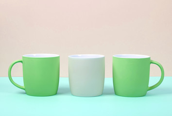 Bright new cups on a solid pastel background.