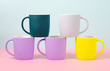 Bright new cups on a solid pastel background.