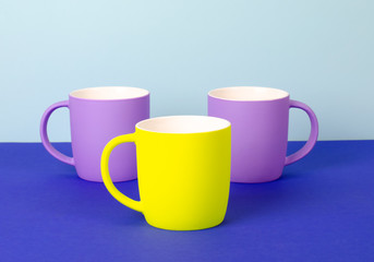 Bright new cups on a solid pastel background.