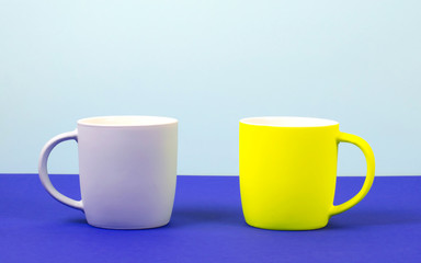 Bright new cups on a solid pastel background.