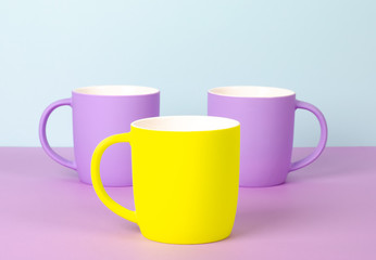 Bright new cups on a solid pastel background.